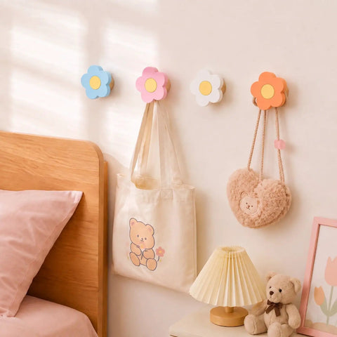 Four Pack Hand Carved Wood Daisy Wall Hooks Decorative Multi Color Coat And Robe Hanger Rack For Bathroom Kitchen Nursery, pink, blue, white, and orange hooks holding bags.