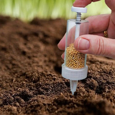 Hand using Mini Seed Spreader Handheld For Tiny Seeds 2025 Upgrade Seed Dispenser in soil for even garden seed coverage.