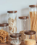 Top Shelf Airtight Glass Storage Jars With Smooth Acacia Wood Lids for pasta, beans, and grains in a kitchen setting.