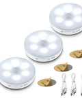 Three Pack Motion Sensor LED Lights Indoor Rechargeable Battery Powered Puck Lights Easy Stick On With 3M Adhesive For Under Cabinet Counter Hallway And Stairs Pure White 6000K, showing three puck lights with adhesive pads and USB cables