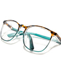 LeonDesigns safety glasses with tortoise shell frames and teal temples, clear lenses.