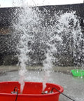 Water spraying from a red bucket using the Top Shelf 12 Volt Dc Solar Water Pump Built Like A Tank For Farm And Ranch Jobs Featuring 26 Feet Of Lift Power Plus 100 Liters Per Minute Flow Through 1 Inch Outlet Stainless Steel Submersible Design Zero Hassle Operation In Vibrant Orange Finish.