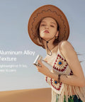 Person holding Portable Handheld Turbo Fan With 100 Speeds And 9000mAh USB Rechargeable Battery, wearing a crochet top and hat.