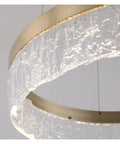 Next Level Gold Round Pendant Light Featuring Three Color Adjustable Aluminum Shade close-up with clear textured glass and warm light.