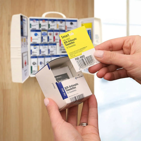 First aid cabinet, front view: large white plastic cabinet opened to reveal boxed medical supplies and medications