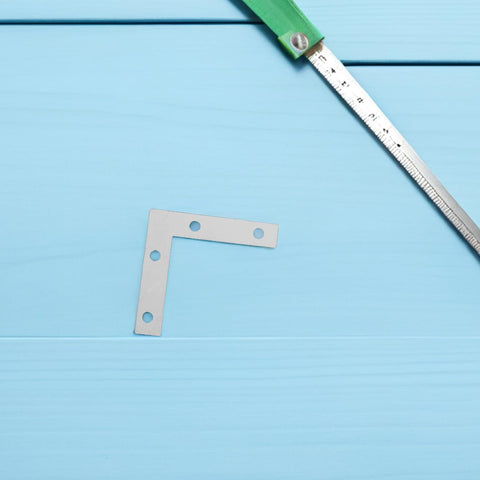 Solid L Shape Corner Brackets 2.17 By 2.17 Inches silver iron on blue background with measuring tape