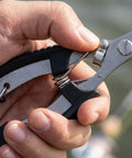 Close-up of hand holding 2 Pack Stainless Steel Fishing Pliers With Lanyard, Needle Nose Hook Remover Set.