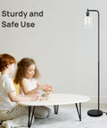 Industrial LED Floor Lamp With Hanging Glass Shade, ST64 9W Vintage Filament Bulb near children playing in living room.