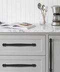 2 Pack 4 Inch Center To Center Black Cabinet Pulls installed on white kitchen drawers with marble countertop.