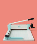 Heavy Duty Guillotine Paper Cutter for 1 Inch Thick Stacks with Easy Operation and Precision Alignment on display against coral background.