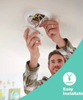 Man installing a Hardwired Smoke And Carbon Monoxide Combo Detector With Adapter Plugs For No Sweat Swap Install And Ten Year Battery Backup.