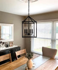 Farmhouse Black Pendant Light Lantern Chandelier For Kitchen Island Foyer Dining Room And Hallway Industrial Style Four Light Fixture With E12 Sockets Measures 17 By Eleven Point Eight Inches No Glass To Clean And Easy Ceiling Mount hanging over a dining table