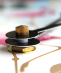 Close-up of Killer 10 Point 5 Inch Silent Wall Clock metal hands and movement mechanism on a colorful background.