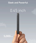 Tiny But Mighty 5000mAh Magnetic Power Bank shown from the side, 0.45 inch thick, held in hand against a cloudy sky background.