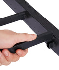 User adjusting the locking mechanism on Heavy Duty Twin Trundle Bed Frame Built Tough For Casual Hangouts And Epic Sleepovers Featuring Roll Out Guest Sleeping Platform Base Zero Sag Steel Slats And Easy Glide Lockable Casters Black.