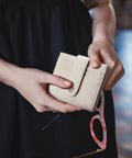 Slim RFID Blocking Wallet For Women, Small Leather Bifold Card Holder With Zipper Coin Pocket, Beige, held in hands