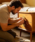 Man installing Dope Gold Brass Floral Dresser Knobs 4 Pack Antique Style Cabinet Drawer Pulls on wooden nightstand