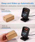 Hands Free 2D Barcode Scanner With Omnidirectional Scanning USB Wired Desktop Reader For 1D And 2D Codes Including PDF417 And Data Matrix Built For Retail Stores Supermarkets Malls And Business Use on marble surface demonstrating auto-sensing feature with a cardboard box.