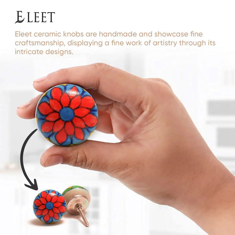 Hand holding a red and blue floral knob from the Multicolor Assorted Ceramic Cabinet Knobs Set Of 20 With Vintage Cupboard Drawer Pulls And Chrome Hardware.