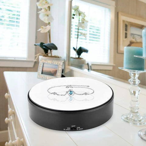 F&Y 360 Degree Electric Rotating Mirror Display Stand With Flexible Speed Turntable For Jewelry showcasing a bracelet on a sleek surface.