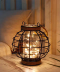Battery Powered Metal Cage LED Lantern 7.3 Inch Tall Cordless Accent Light With 20 Fairy Lights on a tabletop indoors
