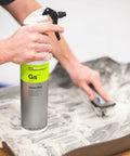 Person cleaning a rubber mat with a spray bottle and brush using All In One Car And Workshop Universal Cleaner Highly Concentrated And Dilutable.