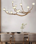 Modern Glass Bubble Chandelier With Sleek Wood Branch Accents, Rustic Industrial Flush Mount Pendant Light For Living Room, Adjustable Hanging Lamp above a dining table.