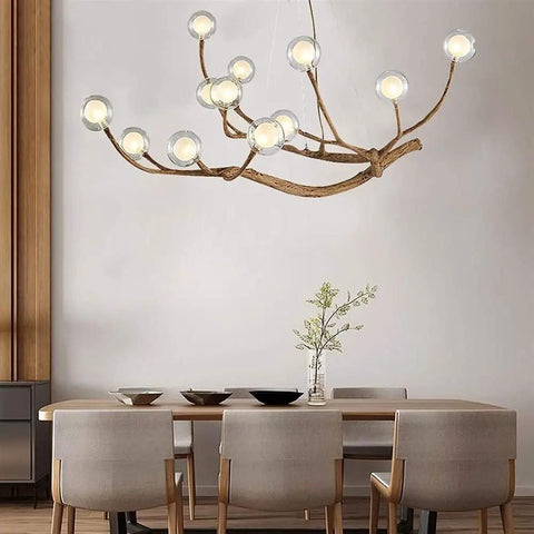 Modern Glass Bubble Chandelier With Sleek Wood Branch Accents, Rustic Industrial Flush Mount Pendant Light For Living Room, Adjustable Hanging Lamp above a dining table.