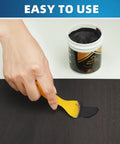 Black Wood Filler Paste Kit High Performance Wood Hole Filler For Cracks And Dings Paintable Stainable Sandable Quick Drying Easy Finish That Never Shrinks Or Cracks 9.87 Ounce being applied to wood with spatula