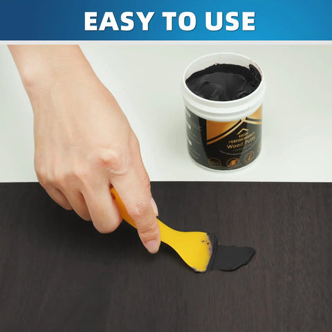 Black Wood Filler Paste Kit High Performance Wood Hole Filler For Cracks And Dings Paintable Stainable Sandable Quick Drying Easy Finish That Never Shrinks Or Cracks 9.87 Ounce being applied to wood with spatula