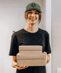 Person wearing Full Moon USA Flag Statement Hat For Men Trucker Cap Army Green Dope Cool Breathable Baseball Cap holding boxes