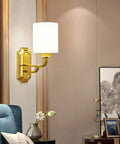 Solid Brass Wall Sconce With Smooth White Glass Shade Modern E27 Light Fixture mounted beside a blue bed, enhancing bedroom ambiance.