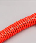 Hella Durable Coiled Air Compressor Hose Built Damn Tough With Single Layer Polyurethane showing bright red coiled tubing with fittings.