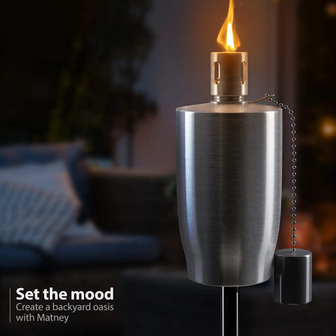 Close-up of stainless steel outdoor torch with lit flame and snuffer cap, part of 5 ft citronella oil lamp set for backyard.