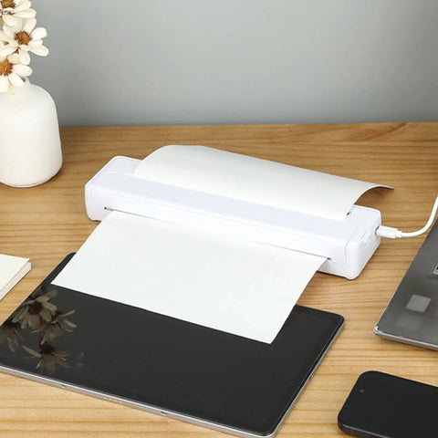 Slick Wireless Tattoo Transfer Stencil Printer For A4 Paper Mini Thermal Stencil on wooden desk with papers and electronics.