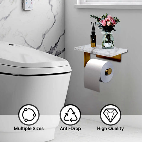 Dope Mega Roll Toilet Paper Holder With Natural Marble Shelf in brushed gold, wall mounted next to toilet, holding toilet paper and decor.