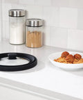 Mess Free Microwave Splatter Cover With Foldable Design next to spaghetti and meatballs on counter