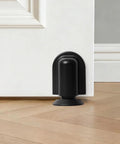 Matte Black Magnetic Door Stopper Holds Interior Doors Firmly Open Heavy Duty Floor Mounted Catch with screw install on hardwood.