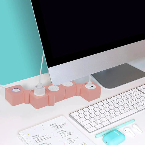 Pink Power Strip With Surge Protection, 3 AC Outlets And 2 USB Ports, Flexible Twist Design For Desk Or Floor, next to monitor on desk