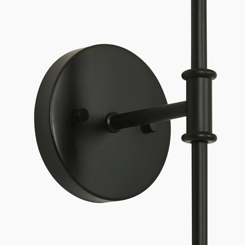 Close-up view of KSANA Modern Black Wall Scone Lighting Indoor with White Fabric Shade's round backplate and vertical stem in matte black.