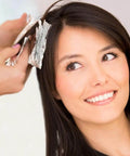Hairdresser applying color using Embossed Pre-Cut Hair Foil Sheets In Pop-Up Dispenser, 5W X 10.75L, on woman's hair