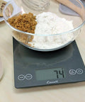 Glass Digital Kitchen Scale With 15 Pound Capacity, Big Backlit Display, Easy Touch Controls, Nutrition And Calorie Counter For Baking And Cooking, 0.1 Oz Or 1 g Accuracy, 9 By 6.5 Inch, Gray Storm showing 74 grams with flour and sugar in a bowl