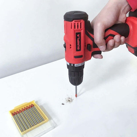Side view of Gunpla cordless drill with 6mm masonry bit; red and black tool with yellow bit set visible.