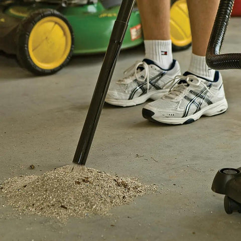 Person using All Purpose Ash Vacuum For Fireplaces And Grills With 10 Amp Power to clean ash from a garage floor