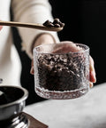 Top Shelf Airtight Glass Storage Jars 320 Milliliters With Durable Sealed Lids For Coffee Beans, held with coffee beans inside.