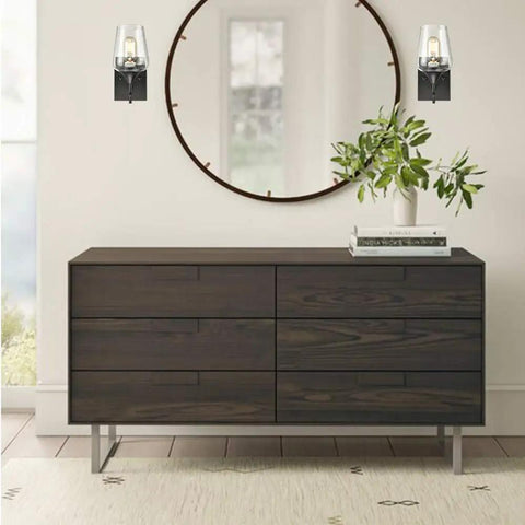 Room with dope matte black industrial wall sconces with clear glass shades near a mirror and wooden dresser