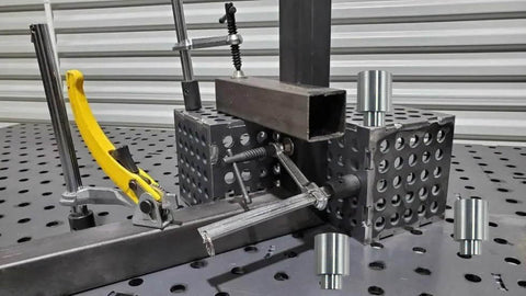 12 Pack Welding Table Fixture Pins Five Eighths By One By One Point Five Inches Aluminum Quick Setup Fixturing Kit with square tube fixed pins in use on a welding table.