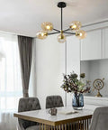 5-Light Sputnik Chandelier With Airblown Glass Globes In Sleek Smoke Grey, adjustable height, in dining area with table and decor.