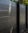Pro Grade Reactive Water Based Wood Stain For Interior Or Exterior Creates A Badass Smoked Black Brown Finish on a wooden fence.