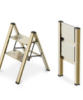 Two Step Aluminum Folding Ladder For Home Use Lightweight Portable Step Stool With Anti Slip Pedals Easy Fold 300 Pound Capacity Great For Kitchen Closet And Garage Gold Finish, showing open and folded position
